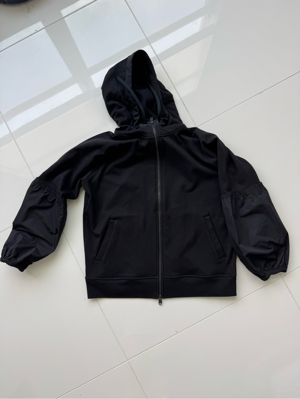 Athleta Black Hooded Zip-Up Jacket with poplin sleeve.